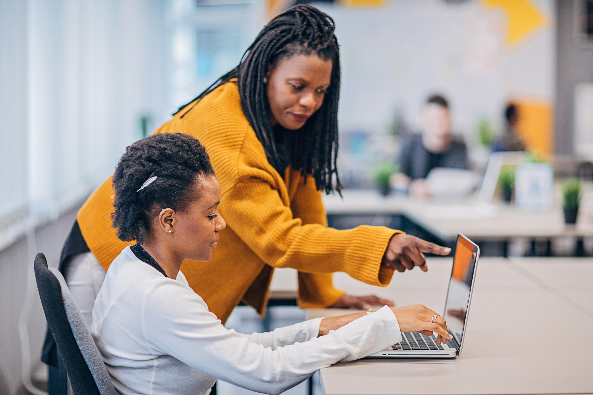 Two black women working together in big modern office